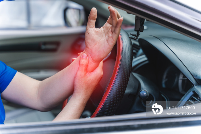 wrist pain from long driving. Middle-aged man holds his wrist and sits in car. Feeling painful.