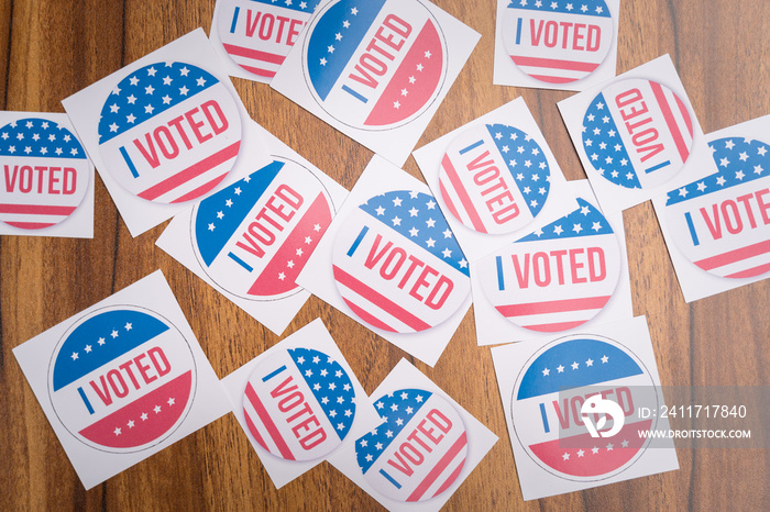 Multiple I Voted stickers on table - concept of voter fraud showing many I voted stickers.