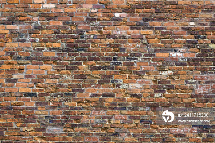 Weathered old red brick wall on a building in Winchcombe, Gloucestershire, UK.