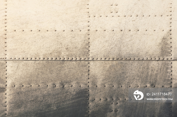 Old metal silver surface of the aircraft fuselage with rivets