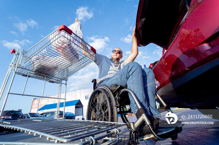 Person with a physical disability puts purchases in the trunk of a car in a supermarket parking lot