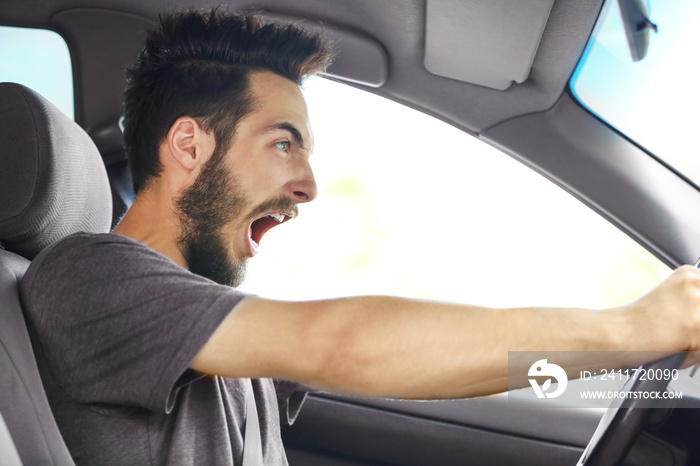 Portrait of handsome young man driving car