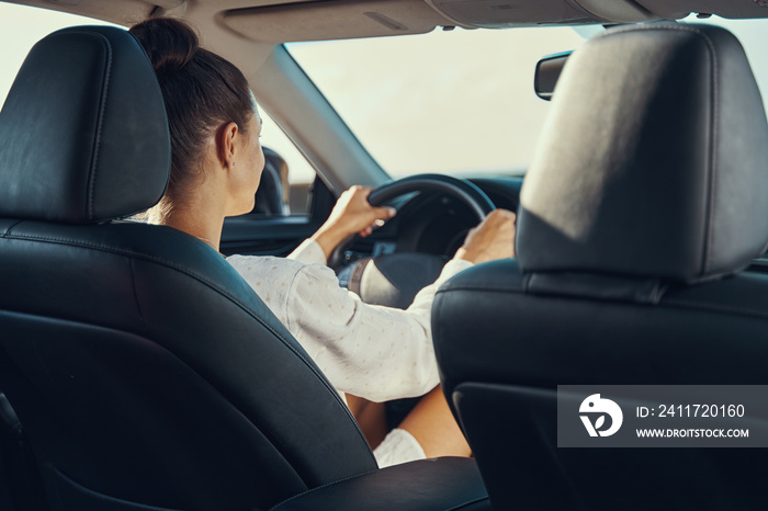 Behind view of woman focused on the road while driving