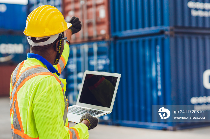 Computer laptop blank screen with back view of foreman staff worker working in logistic control loading containers at port cargo to trucks for export and import goods.