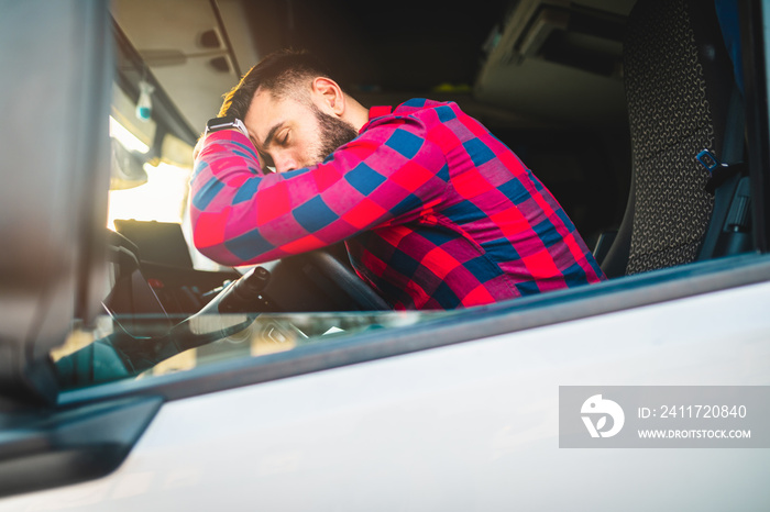 Young bearded truck driver resting in his truck.