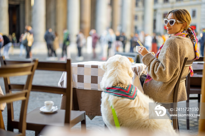 Woman sitting with her dog at outdoor cafe near famous Pantheon temple in Rome. Idea of spending time in Rome. Concept of italian lifestyle and travel