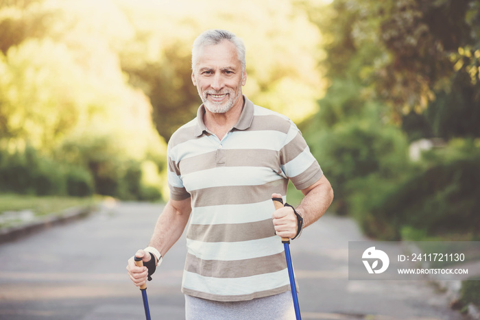 Joyful pleasant man using poles