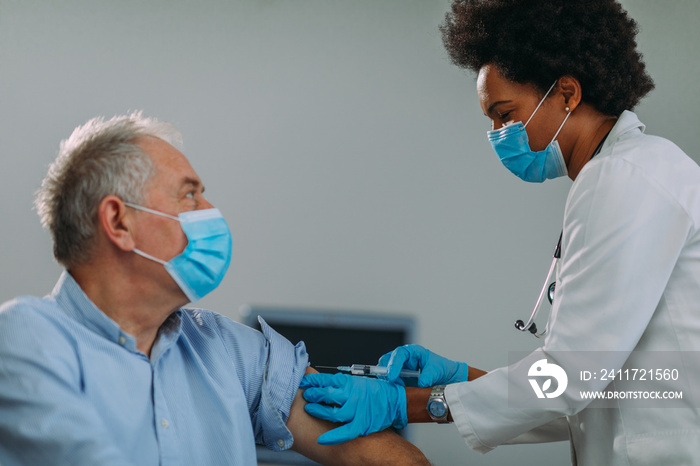 Senior man getting vaccinated at hospital