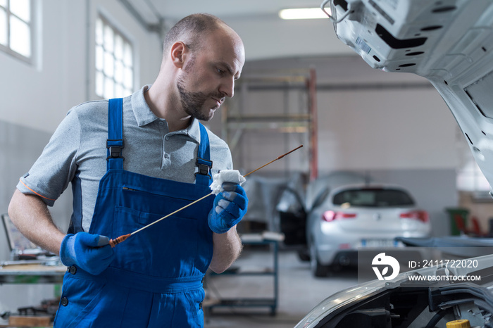 Mechanic checking a car’s oil level in the garage