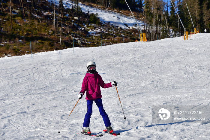 Girl learning to ski on the snow on the hill