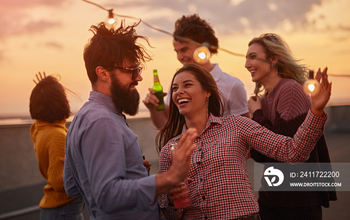 Excited friends dancing during party