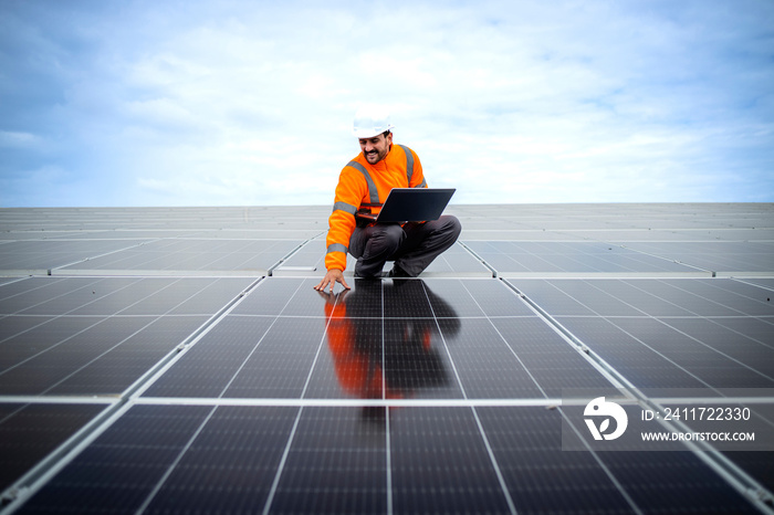 Solar energy worker looking straight to the photovoltaic panels generating electricity for sustainable energy.