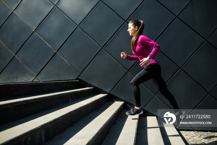 Athletic woman running up stairs during cardio. interval training