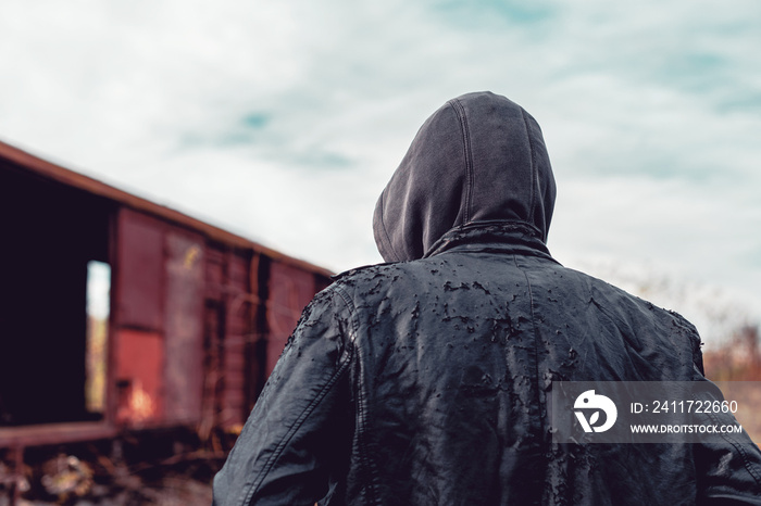 Homeless immigrant walking by freight train wagons