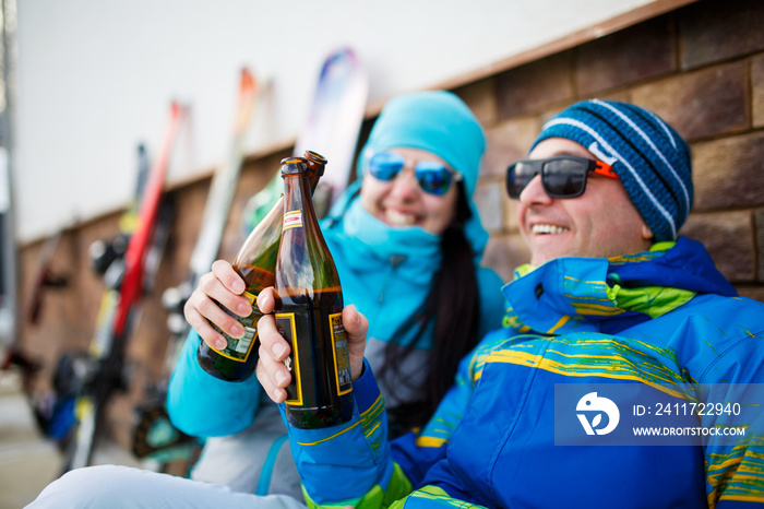 Photo of cheerful man and woman in sunglasses with beer on winter day