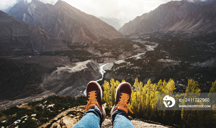 Woman on a cliff overlooking the mountains and a valley