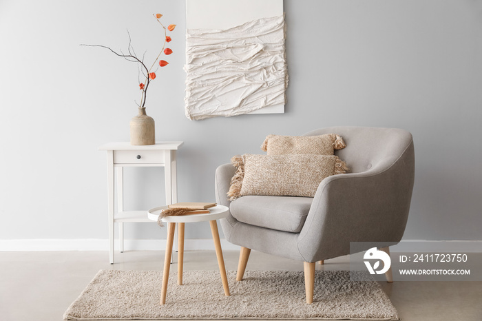 Interior of modern living room with armchair, tables and 3D textile artwork