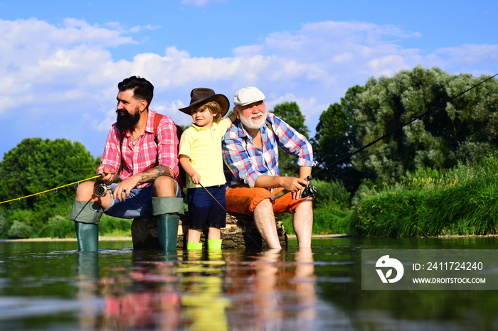 I love fishing. Fishing in river. Happy grandfather and grandson are fishing on the river. Three generations ages: grandfather, father and young teenager son.