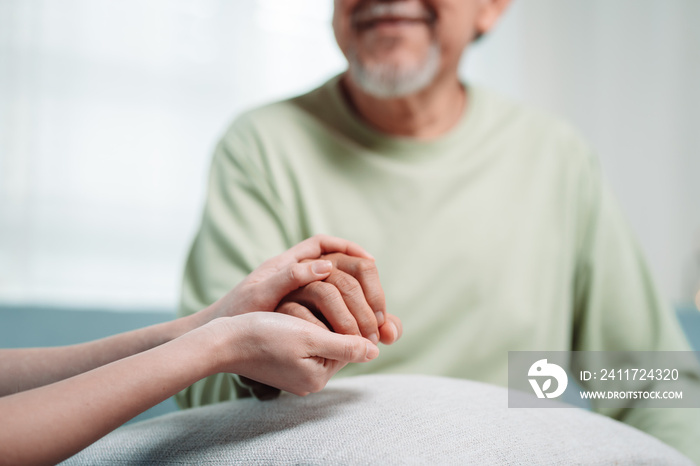 Asian caregiver holding hands senior elderly old male take care mental health care at nursing home.