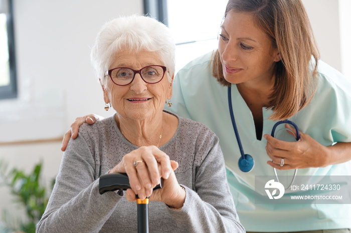 Nurse visiting old woman at home