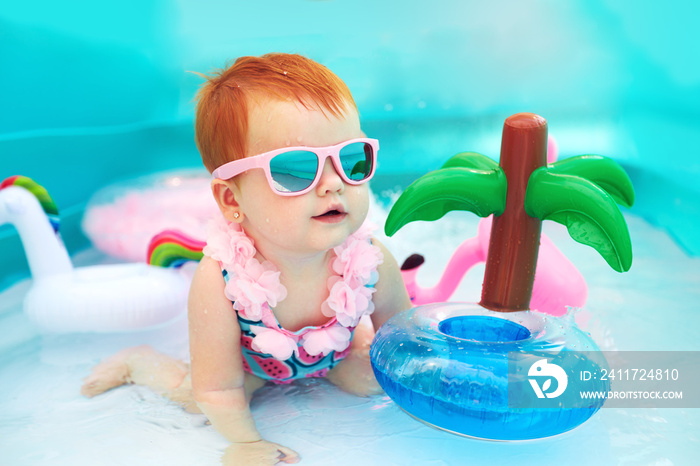 cute happy baby girl having fun in kid pool, summer vacation