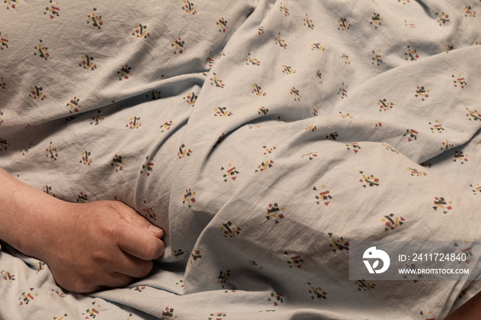 Shape of a man in a hospital gown with only hand visible, healthcare background, creative copy space, horizontal aspect