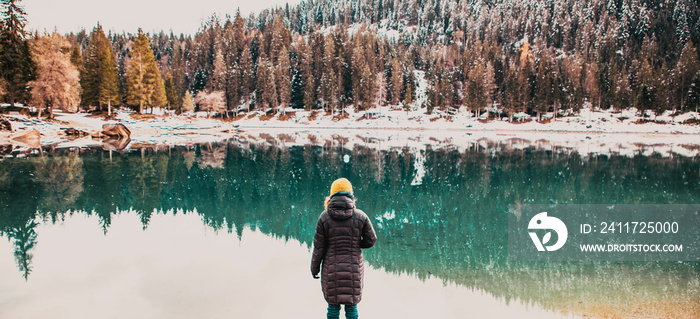 woman watchin amazing turquoise water of Caumasee in winter Switzerland slow travel