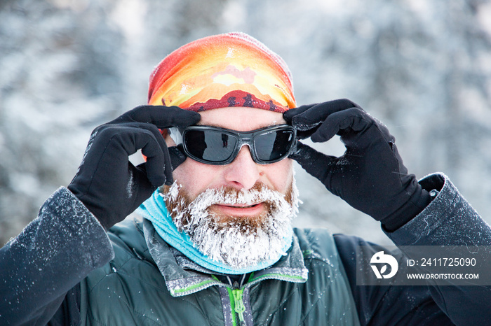 trail runner with frozen beard training in winter landscape