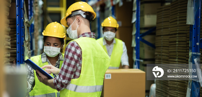 Diverse group of warehouse workers wear protective face mask to prevent COVID-19 infection working and doing inventory in storehouse together. warehouse and inventory concept.