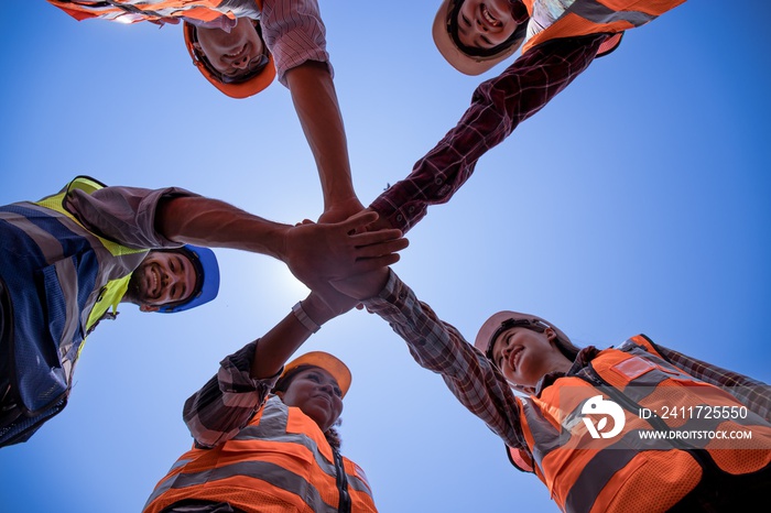 Group of multi-ethnic worker engineers are working together with cheering hands. Concept of people difference in ethnicity,Asian,African,Middle Eastern,male,female,skin color equality,Diverse,target.