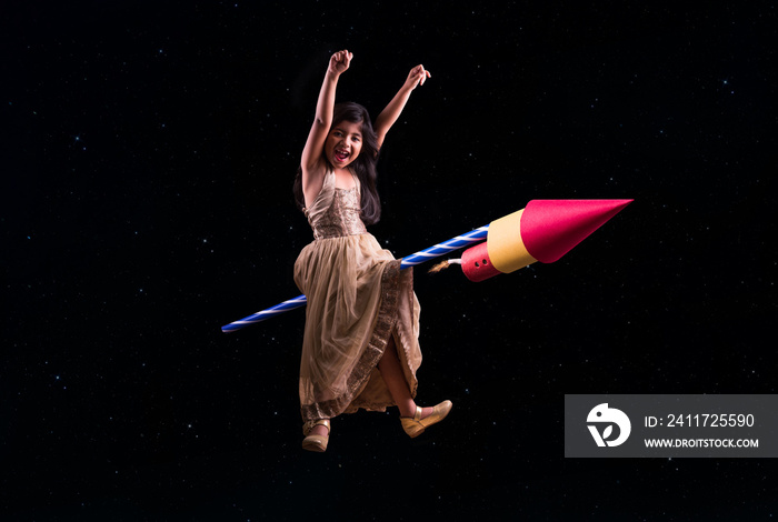 happy diwali greeting showing photograph of happy Indian small girl enjoying firecracker celebrating Diwali, cheerful girl sitting over firecracker or rocket and flying in the space in diwali festival