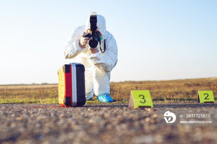 Detective studying a crime scene taking photographs.