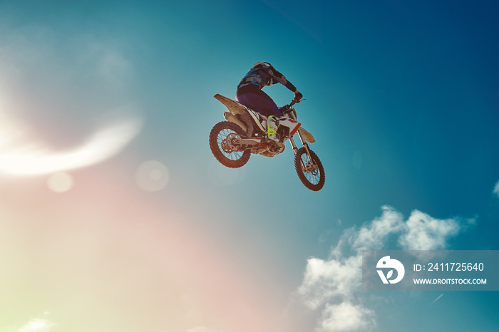 Extreme concept, challenge yourself. Extreme jump on a motorcycle on a background of blue sky with clouds. Copy space, all or nothing.