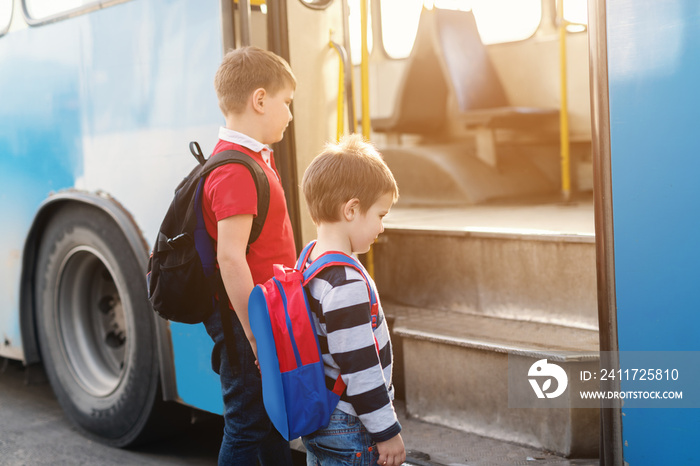 Brothers entering the city bus and going to school. Side view.