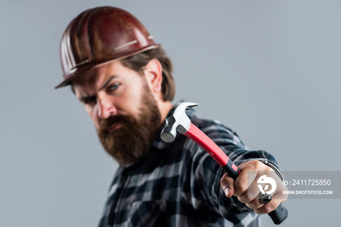 He loves his job. brutal technician builder. factory worker mechanic. industrial worker in helmet. man with hammer tool. construction worker in hard hat. engineer architect working in safety helmet