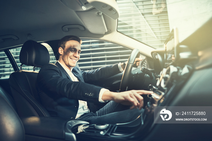 Smiling businessman enjoying a drive through the city