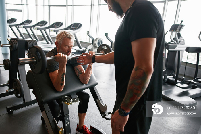 Coach with elder client in gym