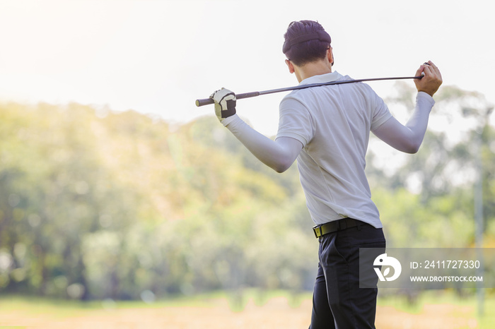 Asian couple playing golf. Man teaching woman to warm up while standing on field