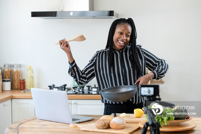 Happy african american woman vlogger broadcasting cooking live video at home