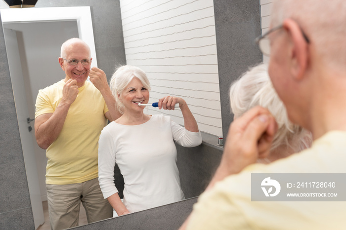 Old senior people cleaning teeth in the bathroom