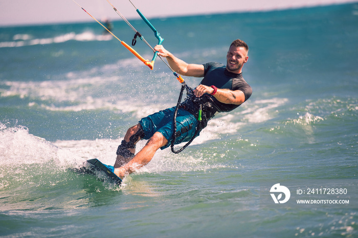 Kitesurfing. Man rides on kite on waves