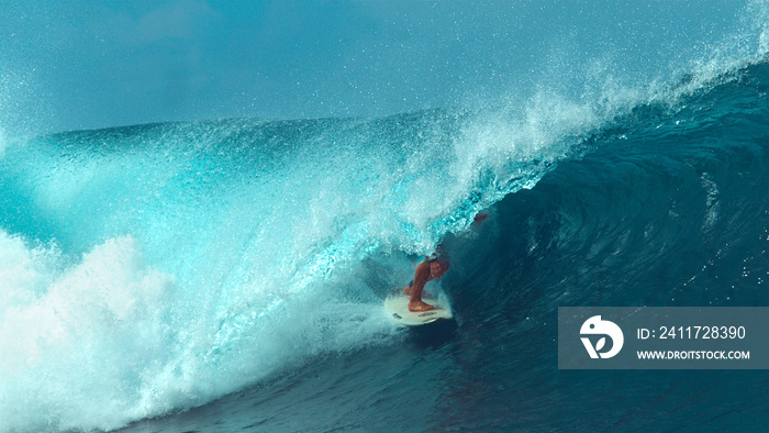 CLOSE UP: Unrecognizable male tourist surfing a cool turquoise barrel wave.