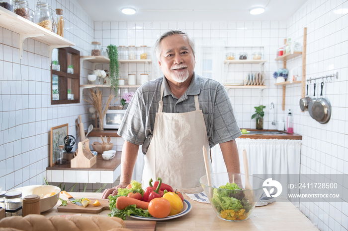 Portrait of happy senior elderly asian grandfather standing cooking meal in kitchen,Old men prepare dinner in hobby lifestyle.