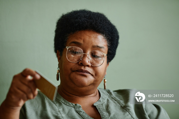 Minimal portrait black woman holding credit card while shopping online from home, copy space