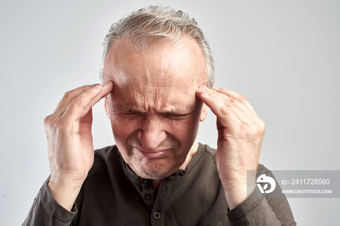 An old man touches his head. Headache. Alzheimer’s disease