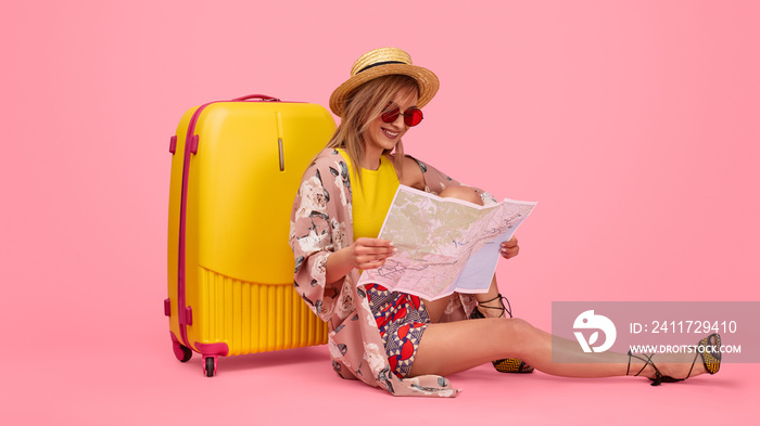 Cheerful tourist reading city map