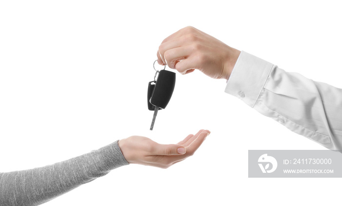 Salesman giving car keys to woman on white background