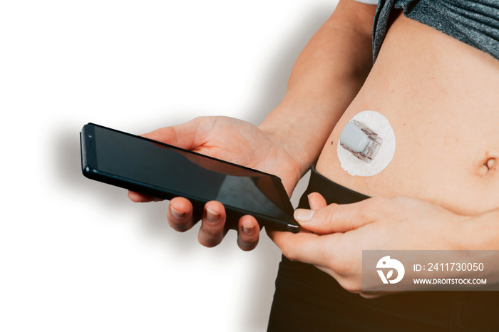 close up of female hands holding a mobile phone nearby a diabetes sensor - glucose monitoring system technology