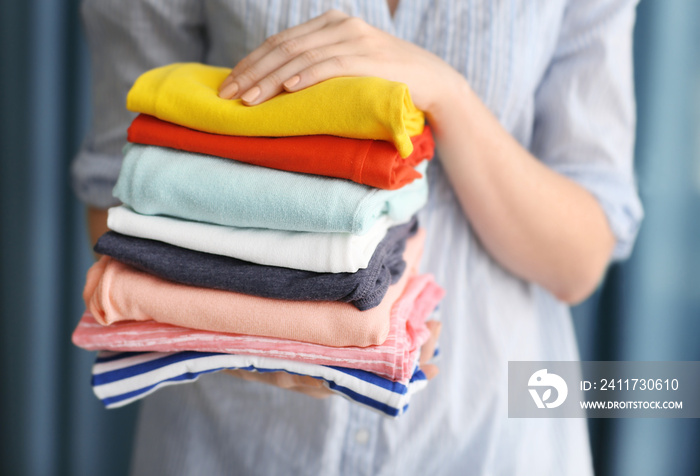 Woman holding stack of clothes, closeup