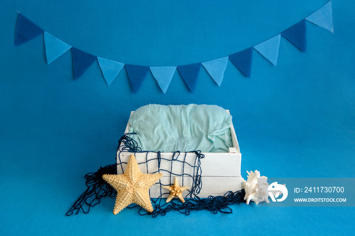 A white box on a blue background is decorated in nautical style. Close-up.